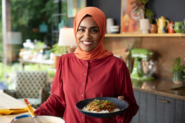 Nadiya's Cook Once, Eat Twice,08-10-2024,Impress For Less,4 - Impress For Less,Nadiya Hussain,holding her Thrifty Banana Peel Curry,Wall to Wall,Tom Kirkman