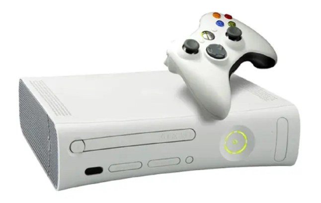 White Xbox 360 console laid horizontally with controller on top of it