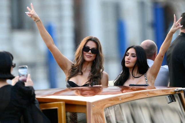 US television personality Kris Jenner takes pictures of US Khloe Kardashian (C) and US reality TV personality Kim Kardashian on a taxi boat as they leave the Gritti Palace Hotel ahead of the wedding of Amazon's founder Jeff Bezos with Lauren Sanchez in Venice on June 26, 2026. Celebrities in superyachts sail into Venice this week for the three-day wedding party of Amazon tycoon Jeff Bezos and Lauren Sanchez, despite irate locals who say the UNESCO city is no billionaire's playground. The tech magnate and journalist have reportedly invited about 200 guests to their multi-million dollar nuptials in the Italian city, which are expected to kick off on June 26 and end Saturday with a ceremony at a secret location. (Photo by Marco BERTORELLO / AFP) (Photo by MARCO BERTORELLO/AFP via Getty Images)