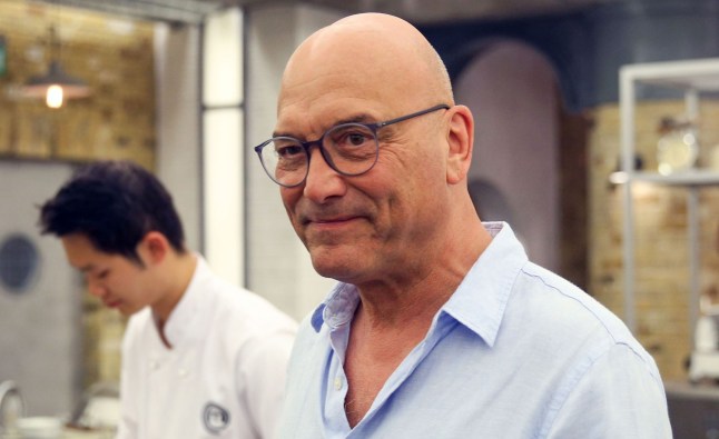 Gregg Wallace smiles in a blue shirt and glasses during a scene from MasterChef.