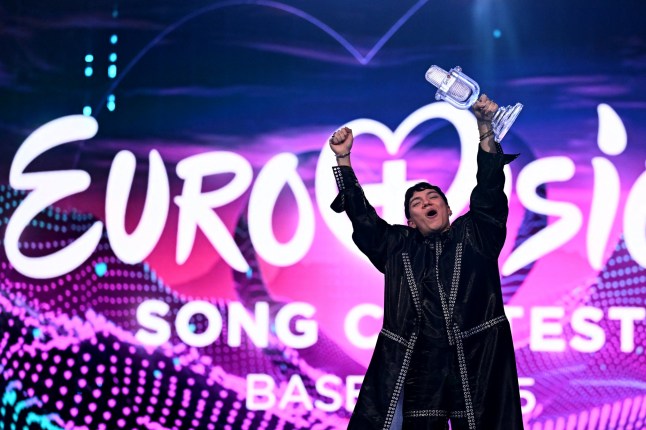 Austrian singer Johannes Pietsch, known as JJ representing Austria with the song "Wasted Love" celebrates with the 2025 Eurovision Song Contest trophy after winning the grand final at the St. Jakobshalle arena in Basel on May 18, 2025. (Photo by Fabrice COFFRINI / AFP) (Photo by FABRICE COFFRINI/AFP via Getty Images)