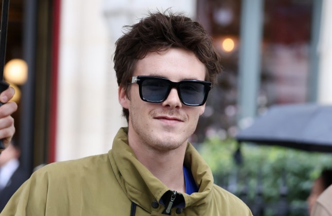 Cruz Beckham in khaki jacket and sunglasses.