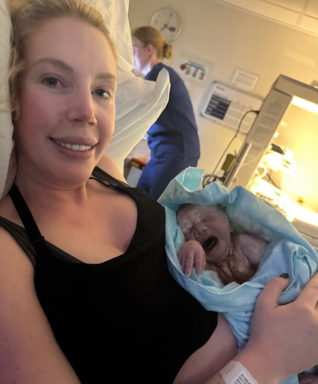 Katherine Ryan in hospital bed with new baby, just after giving birth.