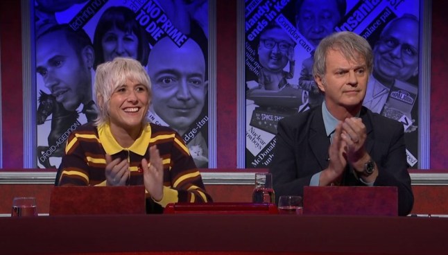 Maisie Adam and Paul Merton on HIGNFY. Adam in yellow-collard rugby shirt, and Merton in dark suit and blue shirt.