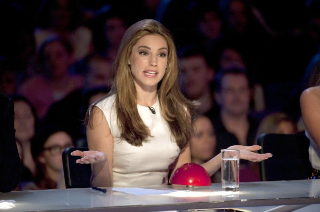 Kelly Brook sat at desk with white top and red buzzer on Britain's Got Talent
