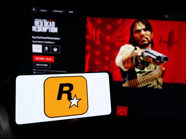 Stuttgart, Germany - 11-14-2023: Person holding cellphone with logo of US video game publishing company Rockstar Games Inc. in front of business webpage. Focus on phone display. Unmodified photo.; Shutterstock ID 2392301355; purchase_order: -; job: -; client: -; other: