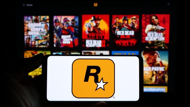 Stuttgart, Germany - 11-14-2023: Person holding smartphone with logo of US video game publishing company Rockstar Games Inc. in front of website. Focus on phone display. Unmodified photo.; Shutterstock ID 2393510359; purchase_order: -; job: -; client: -; other: