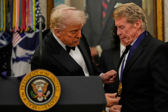 President Donald Trump, left, presents Michael Crawford with his Kennedy Center Honors medal in the Oval Office of the White House, Saturday, Dec. 6, 2025, in Washington. (AP Photo/Julia Demaree Nikhinson)