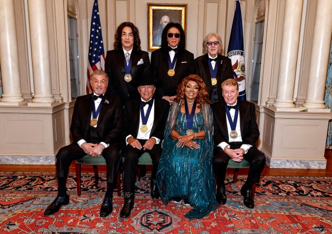 WASHINGTON, DC - DECEMBER 06: Honorees (Back Row L-R) Paul Stanley, Gene Simmons, Peter Criss of KISS and (Front Row L-R) Sylvester Stallone, George Strait, Gloria Gaynor, Michael Crawford pose for the class photo at the 48th Kennedy Center Honors Medallion Reception at the U.S. Department of State on December 06, 2025 in Washington, DC. (Photo by Paul Morigi/Getty Images)