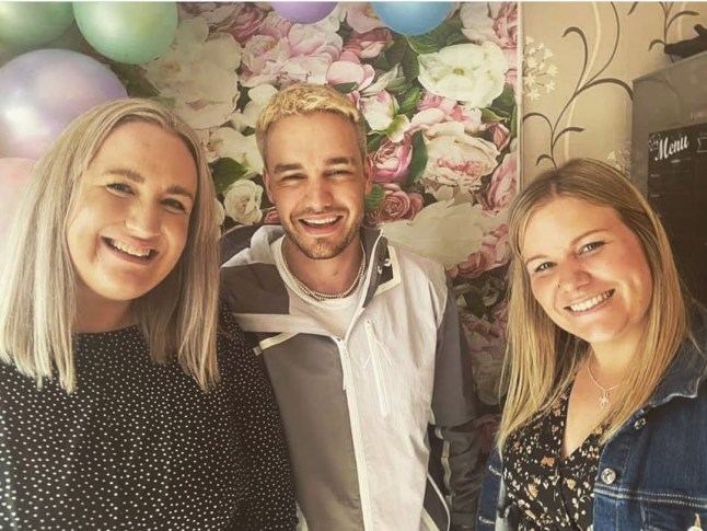 Liam Payne's with blonde hair smiles next to his two sisters with some balloons.